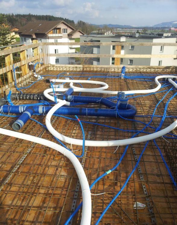 Rohbau-Terrasse mit verlegten blauen und weissen Leitungen
