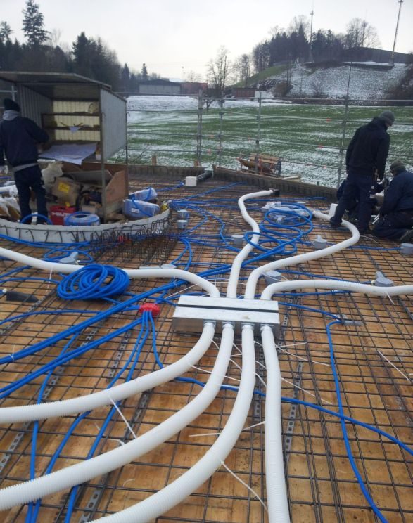 Weisse und blaue Leitungen auf einer Rohbau-Terrasse